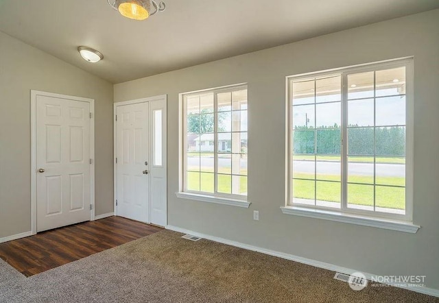 foyer entrance with dark wood-type flooring and lofted ceiling