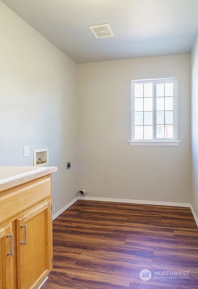 clothes washing area featuring cabinets, hookup for a washing machine, dark hardwood / wood-style flooring, and electric dryer hookup