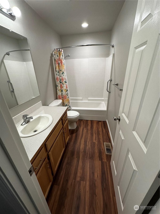 full bathroom featuring hardwood / wood-style floors, vanity, shower / bath combination with curtain, and toilet