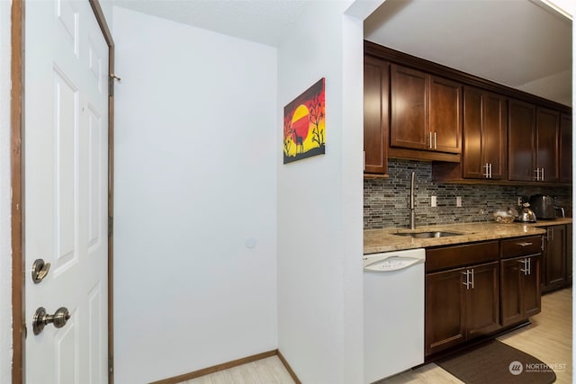 bar with light stone countertops, sink, light hardwood / wood-style flooring, backsplash, and white dishwasher