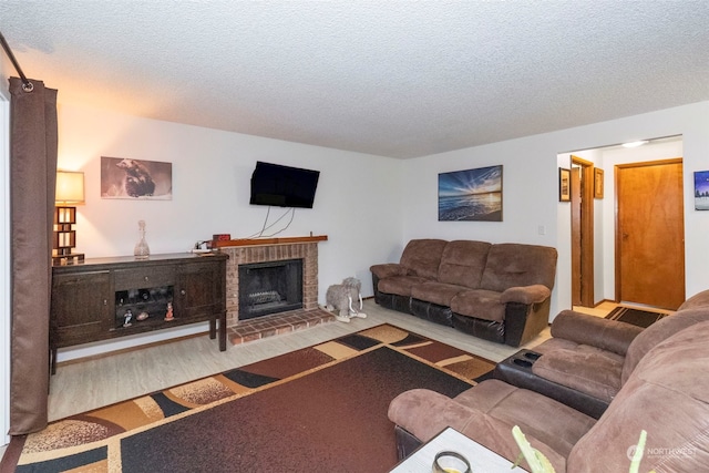 living room featuring hardwood / wood-style floors, a fireplace, and a textured ceiling