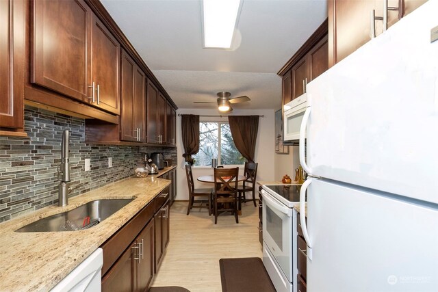 kitchen with white appliances, sink, light hardwood / wood-style flooring, ceiling fan, and decorative backsplash