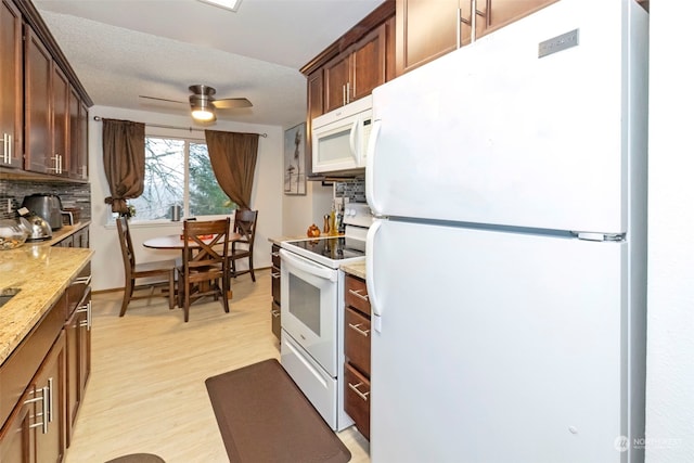 kitchen with ceiling fan, tasteful backsplash, light stone counters, white appliances, and light wood-type flooring