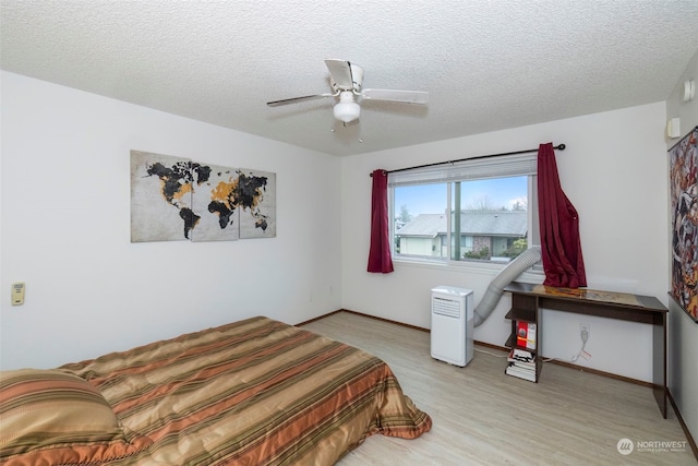 bedroom featuring ceiling fan, a textured ceiling, and light wood-type flooring