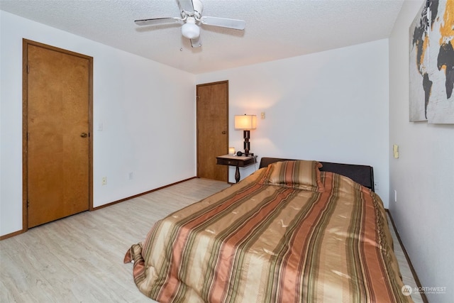 bedroom with a textured ceiling, light wood-type flooring, and ceiling fan