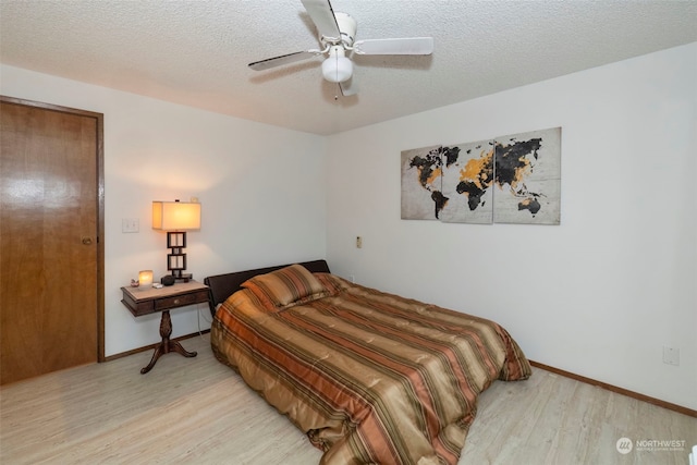 bedroom featuring a textured ceiling, light hardwood / wood-style floors, and ceiling fan