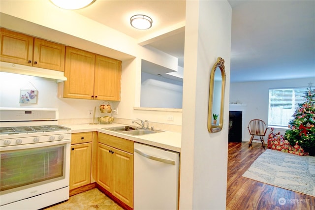 kitchen with sink, white appliances, and light wood-type flooring