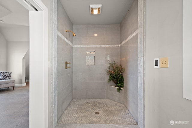 bathroom with a tile shower and tile patterned floors