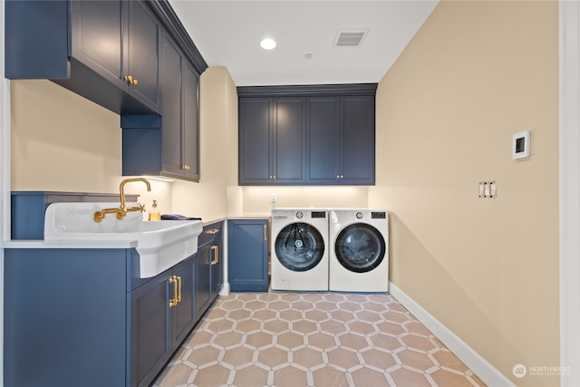 laundry area with cabinets, light tile patterned floors, sink, and washing machine and clothes dryer