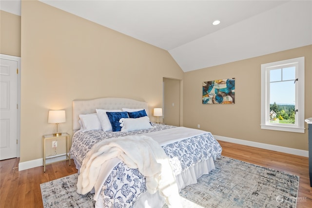 bedroom featuring hardwood / wood-style flooring and vaulted ceiling