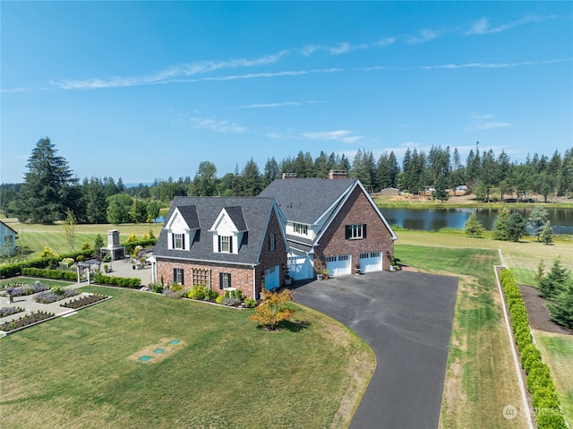 view of front of house featuring a water view, a front yard, and a garage