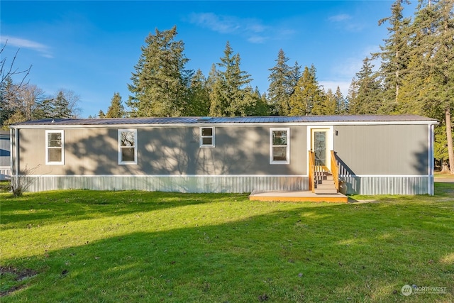 rear view of house featuring a yard