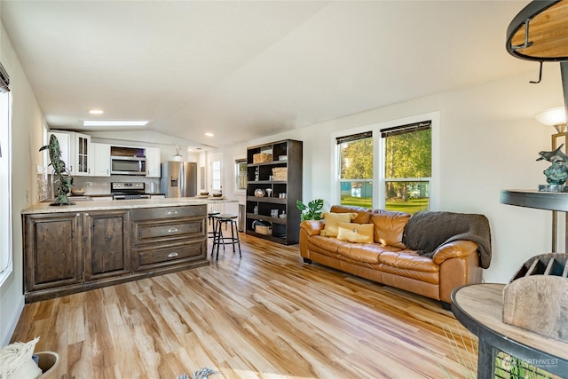 living room with light hardwood / wood-style flooring and lofted ceiling