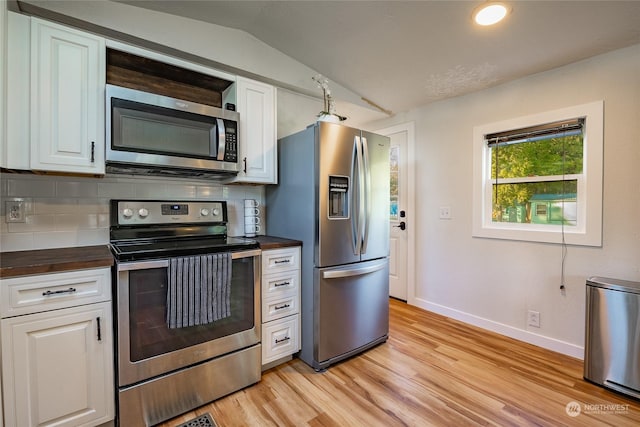 kitchen with backsplash, white cabinets, stainless steel appliances, and lofted ceiling