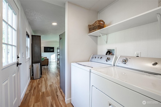 washroom with light hardwood / wood-style flooring and washer and dryer