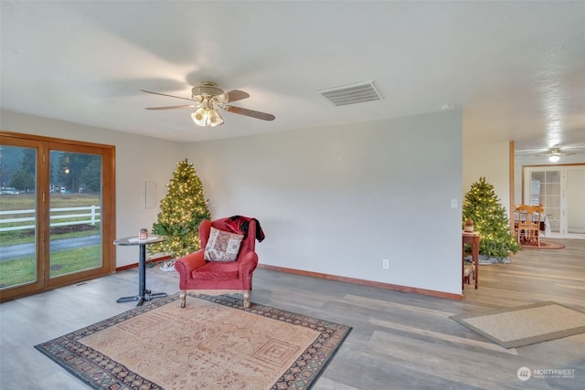 living area with ceiling fan and hardwood / wood-style floors