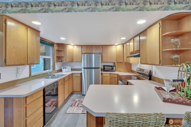 kitchen featuring kitchen peninsula, sink, light hardwood / wood-style floors, and black appliances