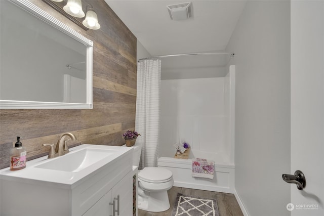 full bathroom with vanity, toilet, wood-type flooring, and shower / tub combo