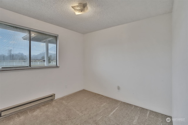 carpeted empty room with a textured ceiling and baseboard heating