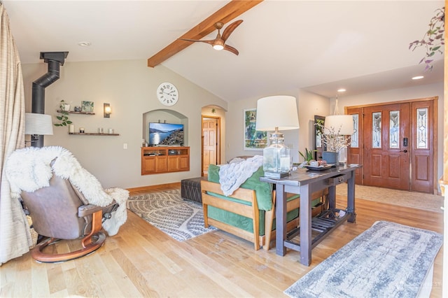 living room featuring vaulted ceiling with beams, light hardwood / wood-style floors, and ceiling fan