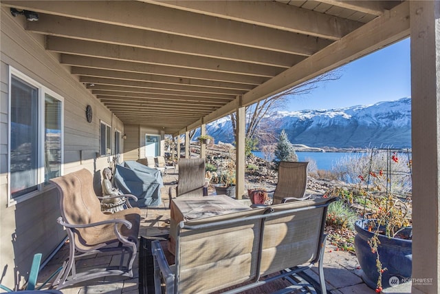 view of patio featuring a water and mountain view