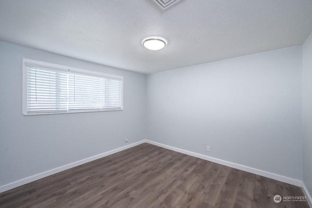 unfurnished room with dark hardwood / wood-style flooring