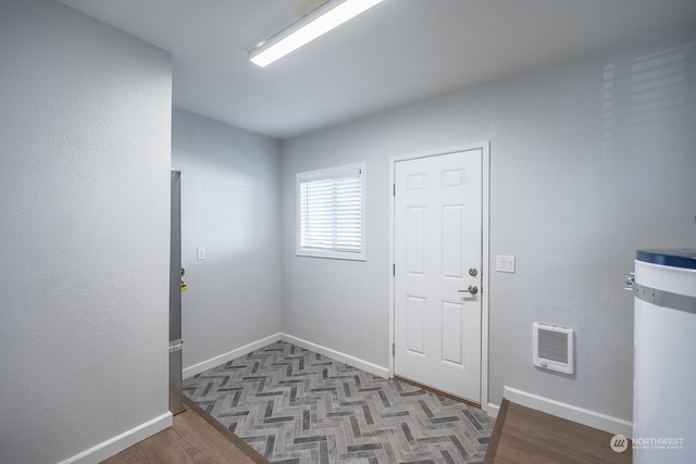 doorway featuring heating unit, strapped water heater, and dark hardwood / wood-style floors