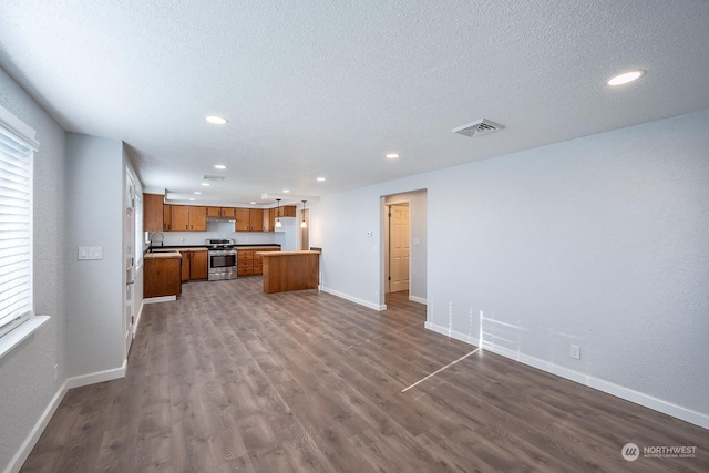 kitchen with sink, stainless steel range oven, a textured ceiling, white fridge, and dark hardwood / wood-style flooring