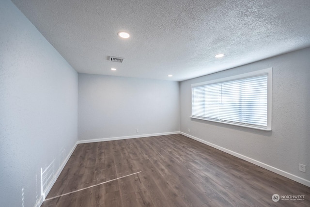 unfurnished room featuring a textured ceiling and dark wood-type flooring