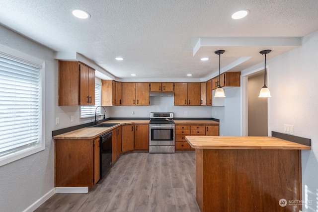 kitchen featuring light wood-type flooring, stainless steel range, sink, dishwasher, and hanging light fixtures