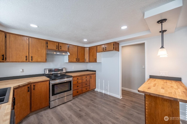 kitchen featuring stainless steel electric range oven, sink, wooden counters, hardwood / wood-style floors, and pendant lighting