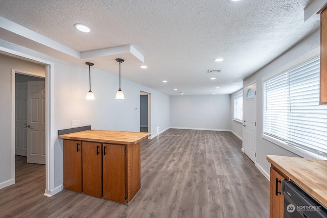 interior space featuring butcher block counters, stainless steel dishwasher, a textured ceiling, decorative light fixtures, and light wood-type flooring