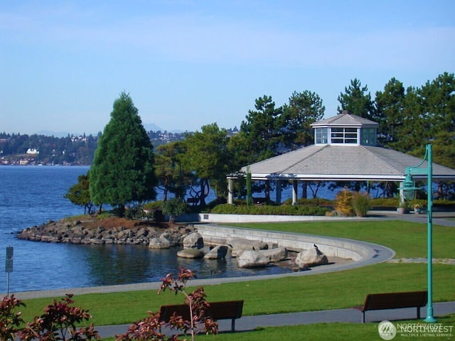 surrounding community with a gazebo, a lawn, and a water view