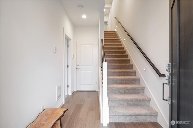 stairs featuring hardwood / wood-style flooring