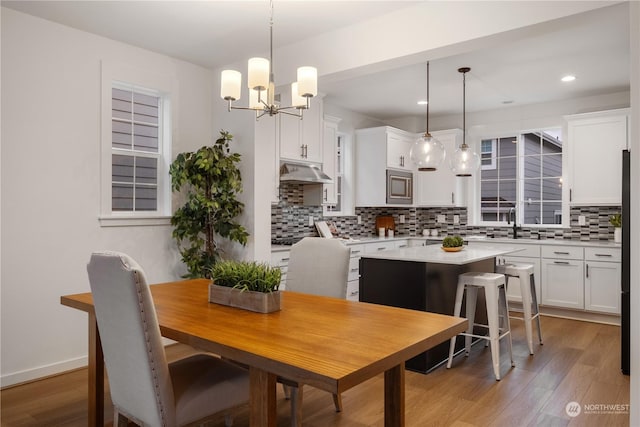 dining area with an inviting chandelier and light hardwood / wood-style flooring