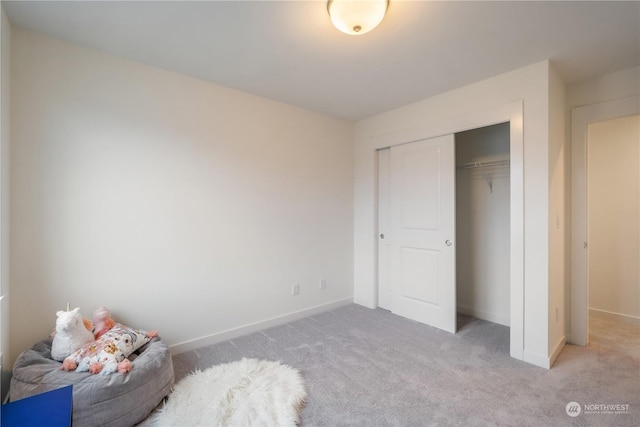 unfurnished bedroom with light carpet and a closet