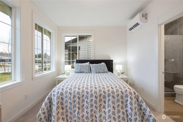 bedroom featuring wood-type flooring, connected bathroom, and a wall mounted AC