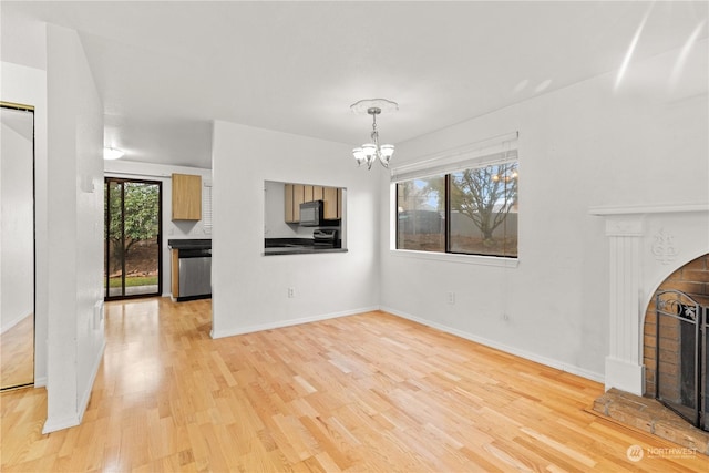 unfurnished living room with light hardwood / wood-style flooring and an inviting chandelier