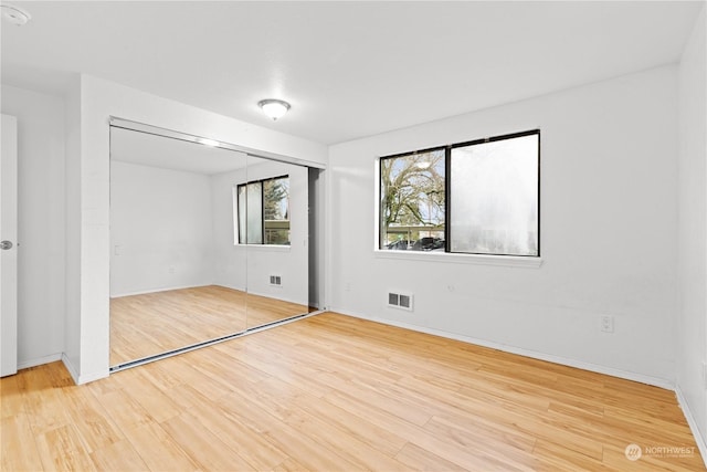 unfurnished bedroom with hardwood / wood-style floors and a closet