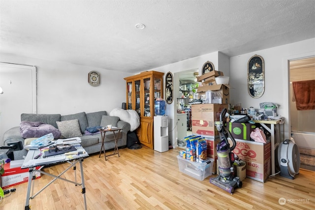 living room with a textured ceiling and light wood-type flooring