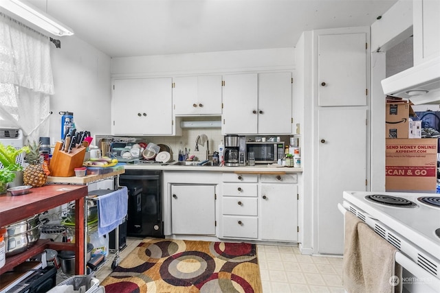 kitchen with white cabinets, electric stove, range hood, and sink