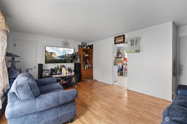 living room featuring wood-type flooring and a textured ceiling