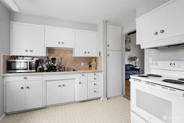 kitchen with white range with electric stovetop, decorative backsplash, white cabinetry, and sink