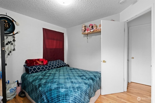 bedroom with hardwood / wood-style flooring and a textured ceiling