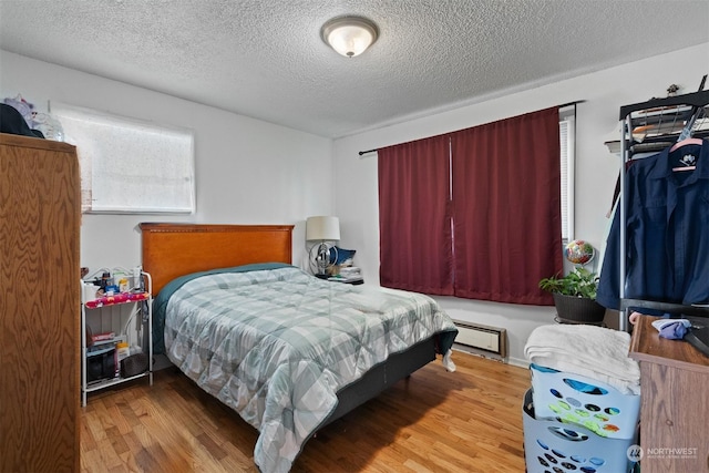 bedroom featuring light hardwood / wood-style floors and a textured ceiling