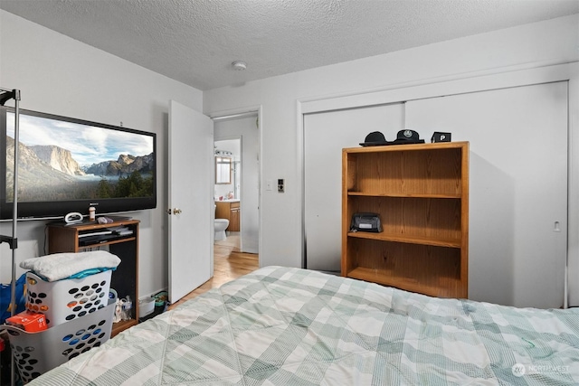 bedroom featuring a textured ceiling, light hardwood / wood-style floors, and a closet