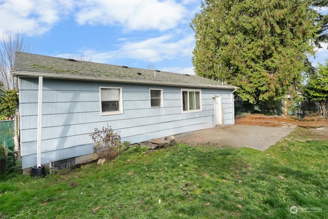 view of property exterior with a yard and a patio