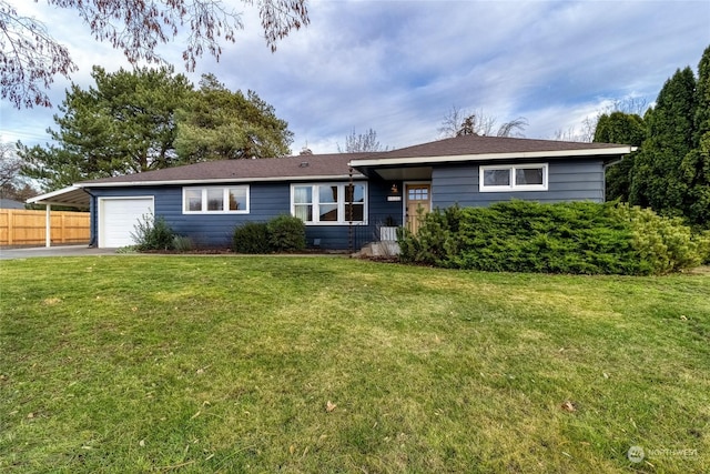 ranch-style home featuring a carport, a garage, and a front lawn