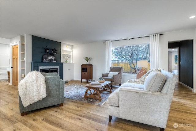 living room with a large fireplace and light wood-type flooring