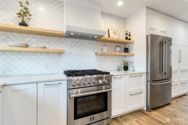 kitchen featuring backsplash, white cabinetry, high end appliances, and exhaust hood